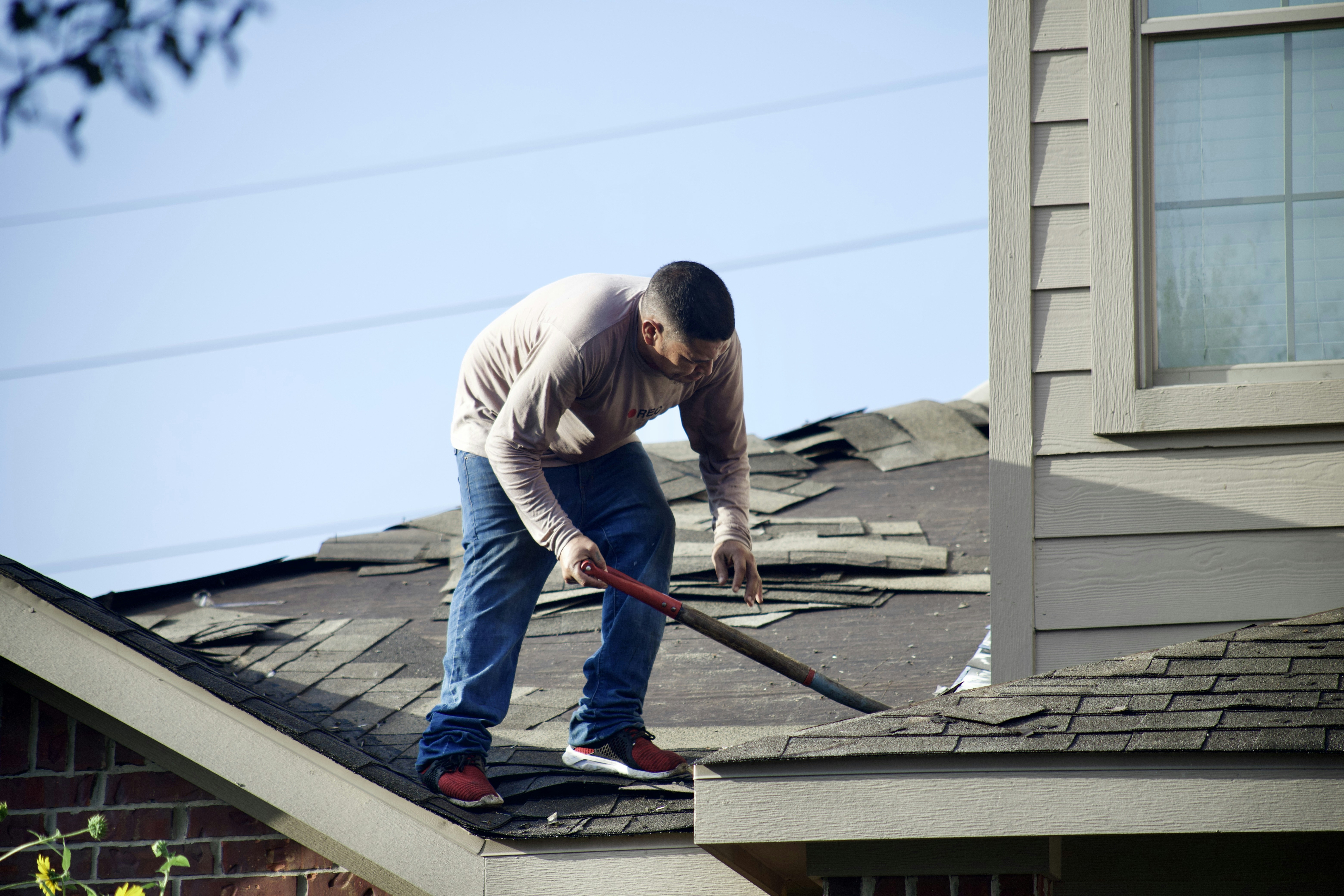 Roofer tearing the roof apart before installing a brand new roof
